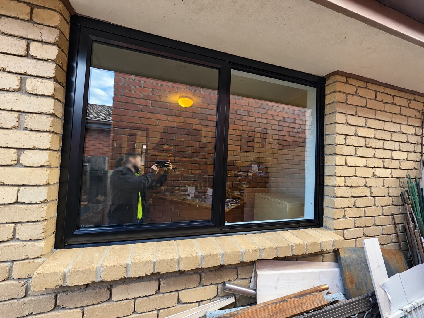 Two-panel black aluminium window set into a cream brick wall